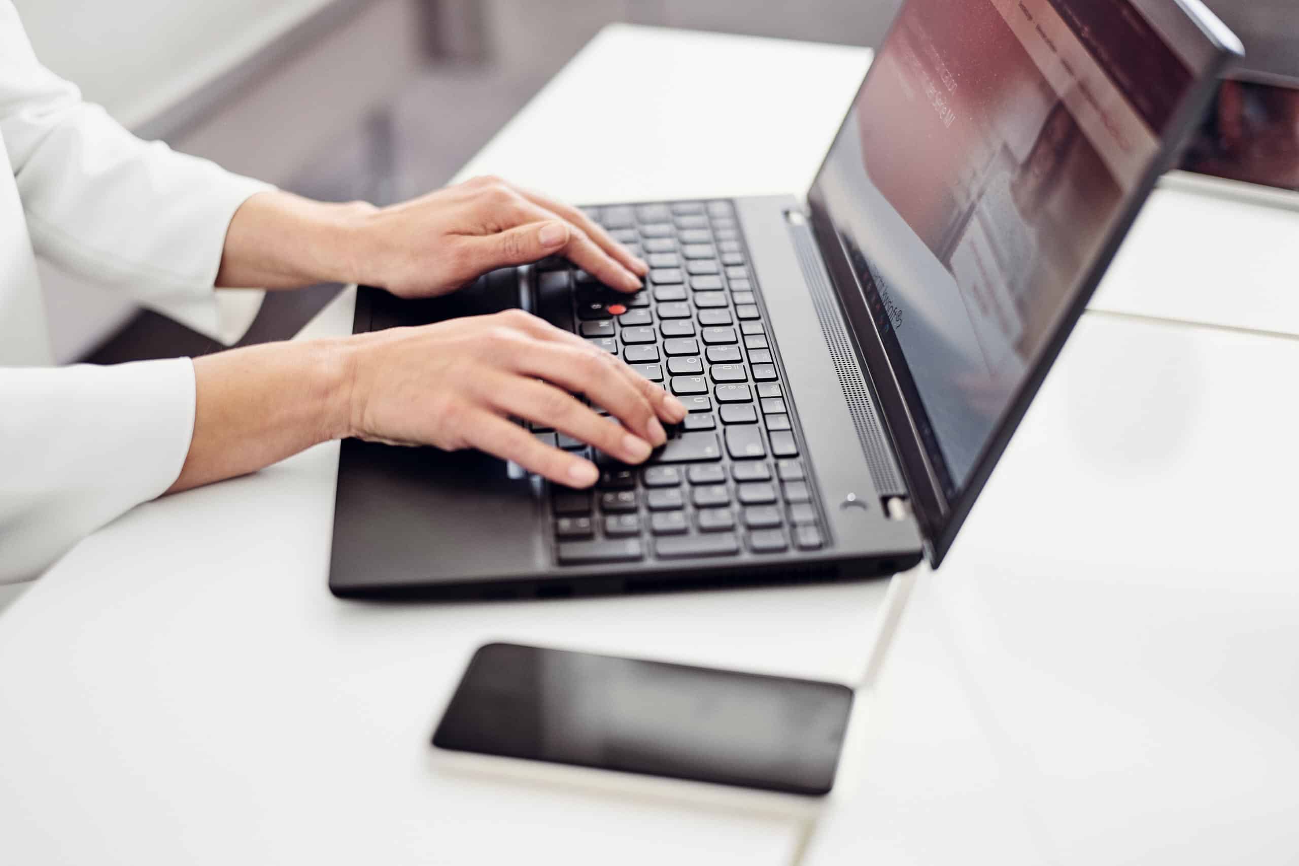 Une personne est assise devant un ordinateur portable et consulte le site web de kwsoft®.