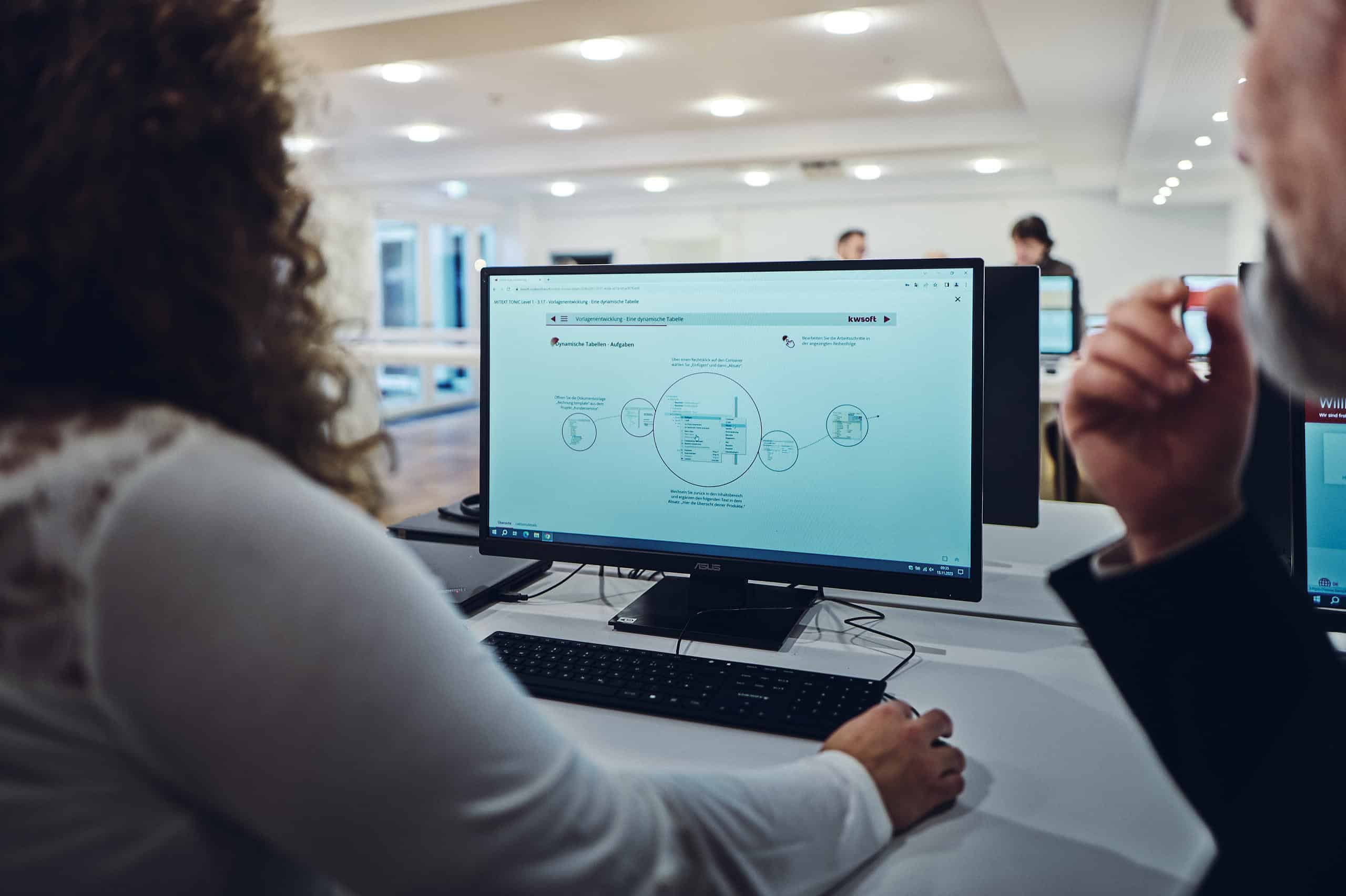 Une personne regarde l'écran et utilise un programme